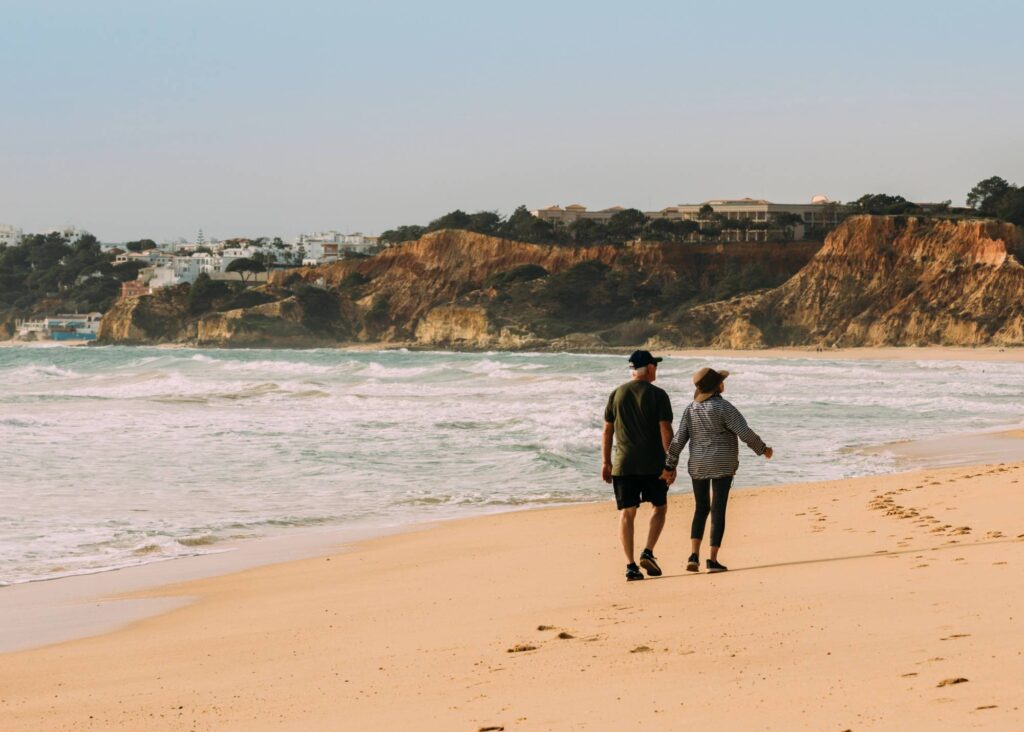 Senior couple walking along the beach in the Algarve