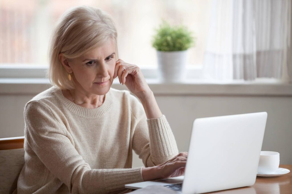 concerned woman looking at her laptop
