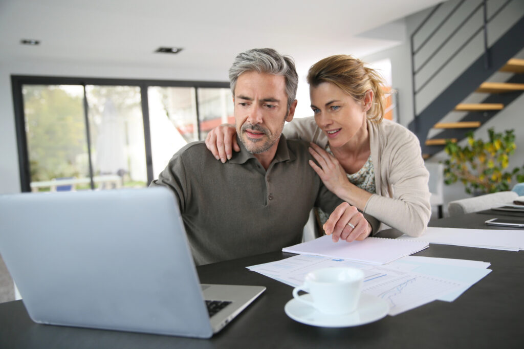 a couple looking at their laptop and going through their finances