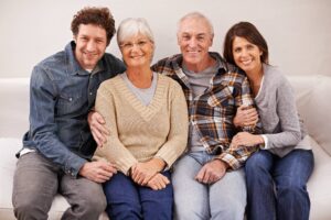 couple with older parents all sitting on the sofa