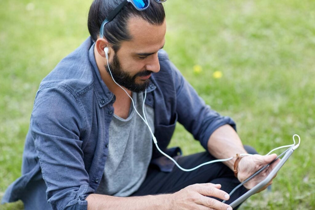 man listening to a podcast on his iPad