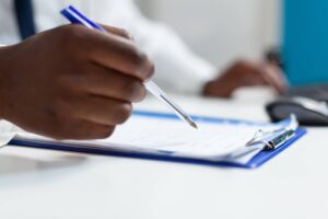 person with blue pen and blue clipboard