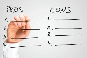 someone writing pros and cons on a glass pane