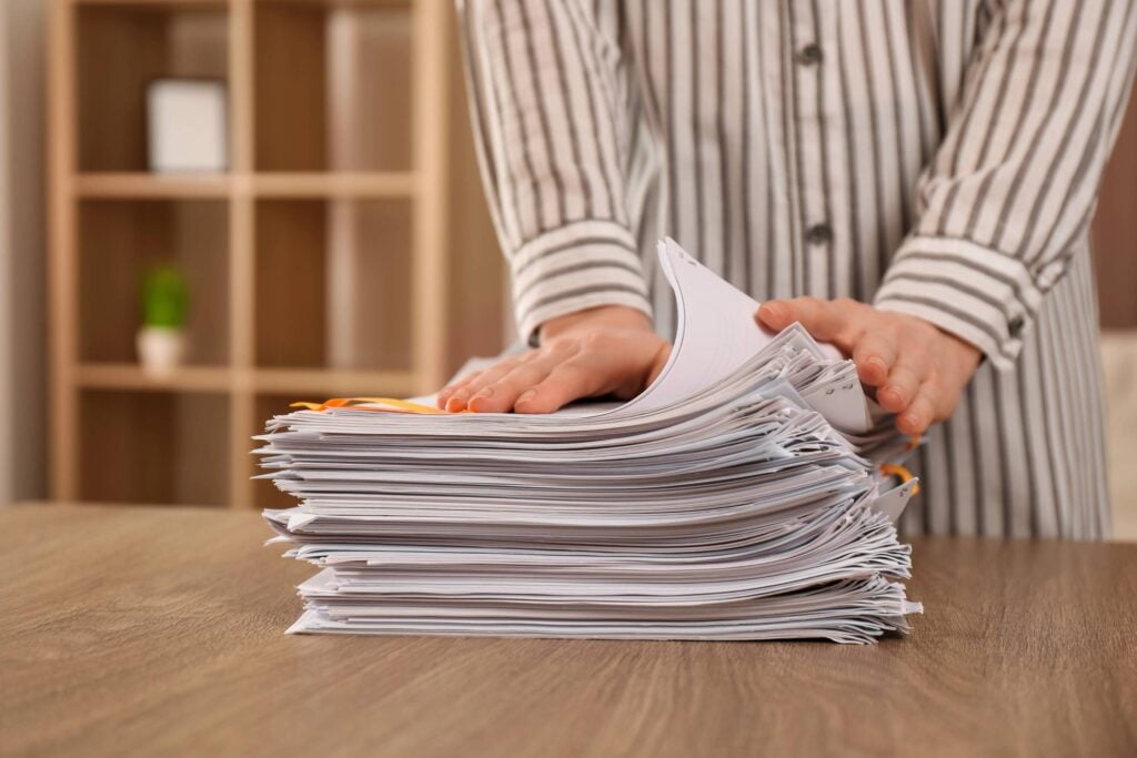 Man putting a stack of documents on the table