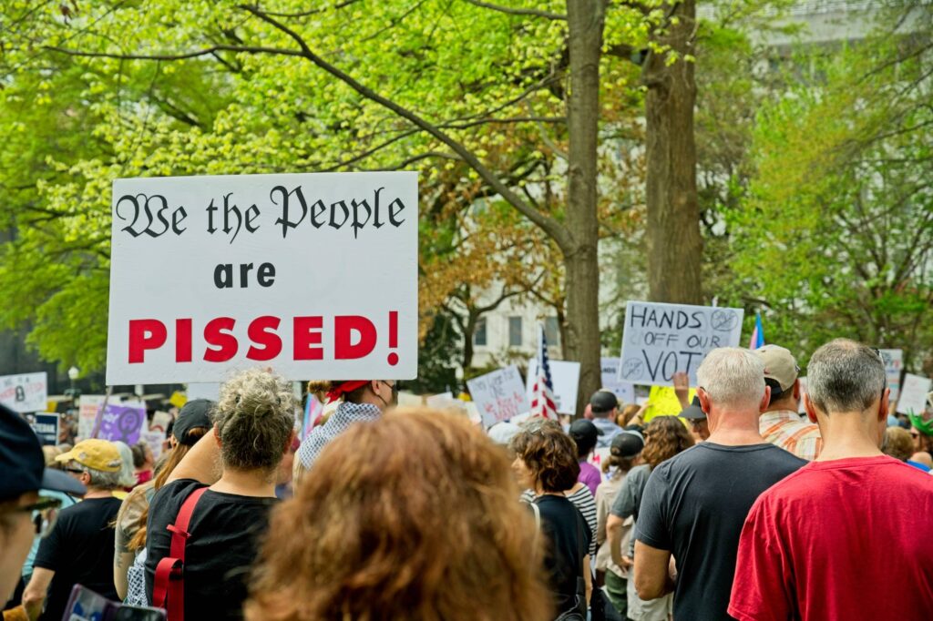 Protester holding sign "we the people are pissed"